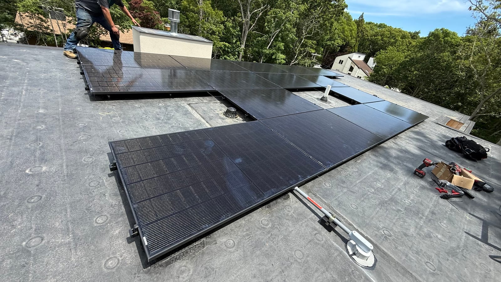 Finished solar array on a flat roof surrounded by woodland