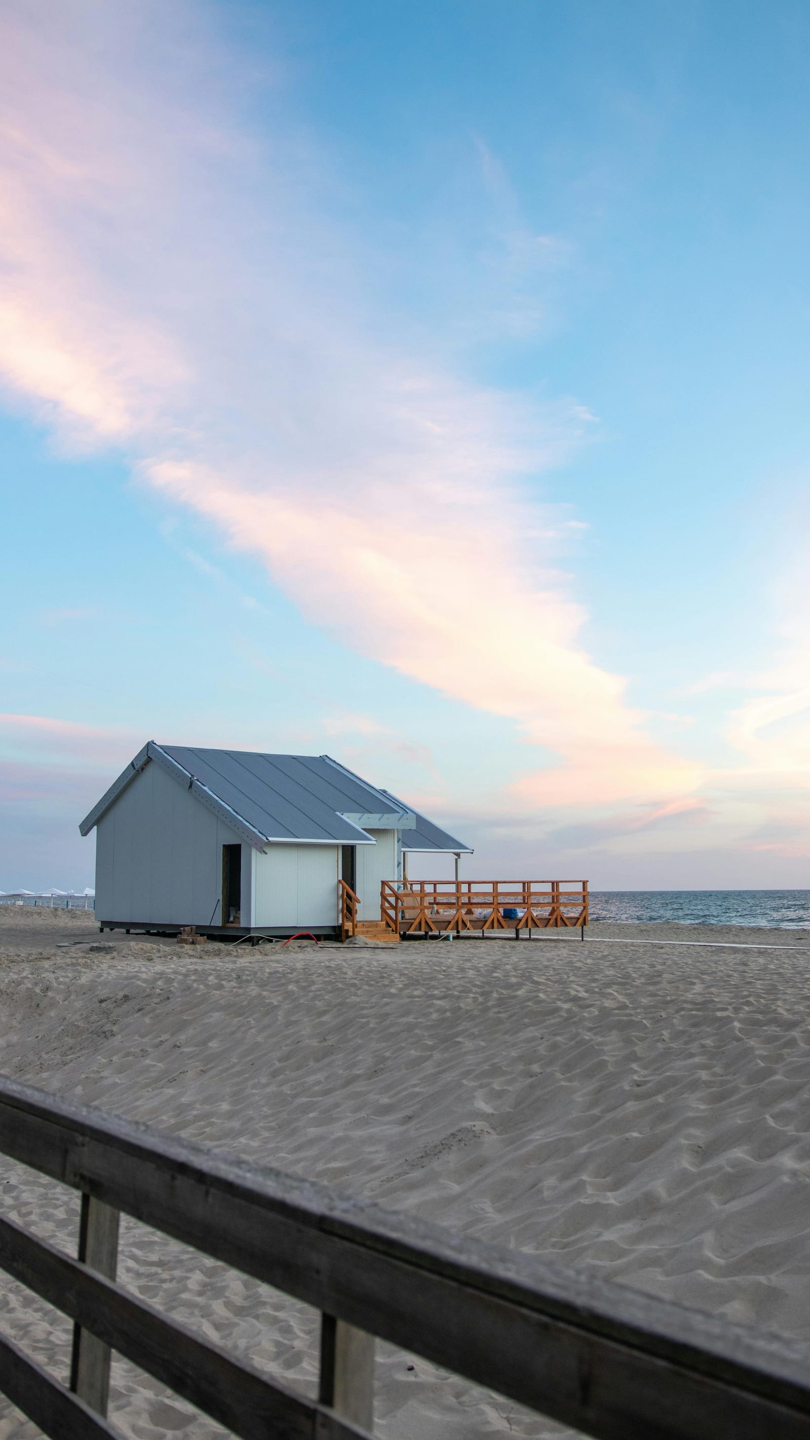 Small waterfront cottage on the beach at sunset