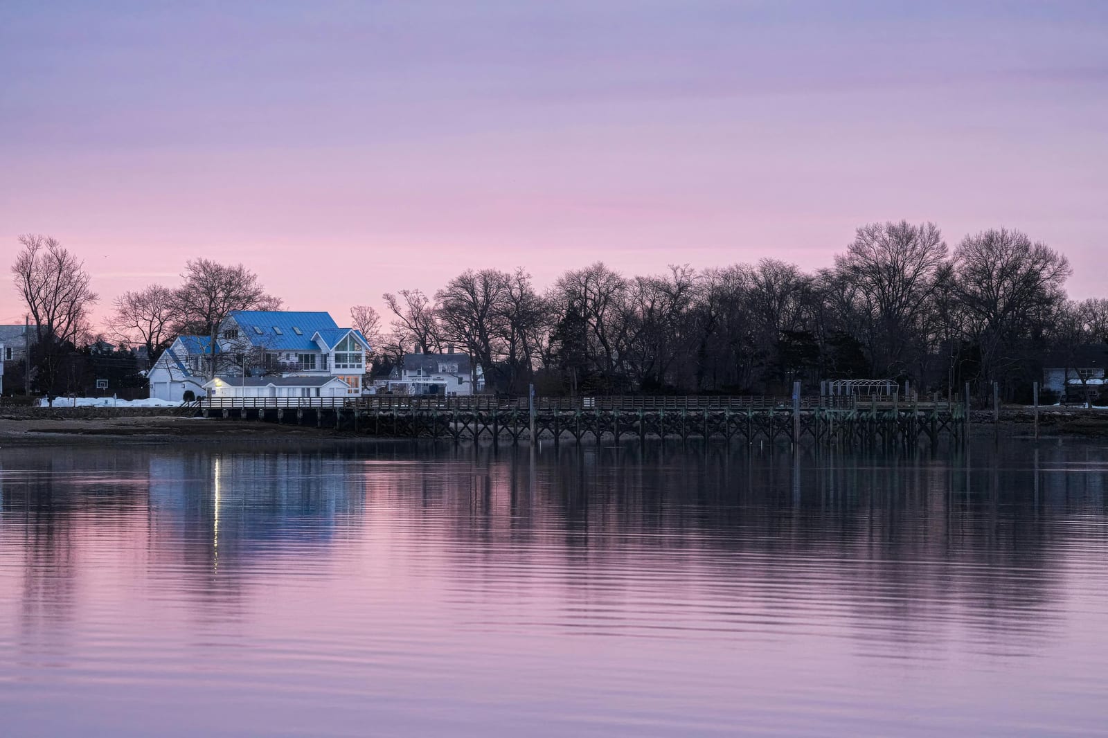 Waterfront homes across calm water at dusk