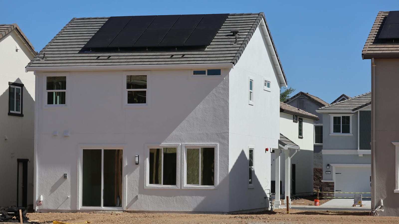 Two-storey white home with a black solar array on its roof