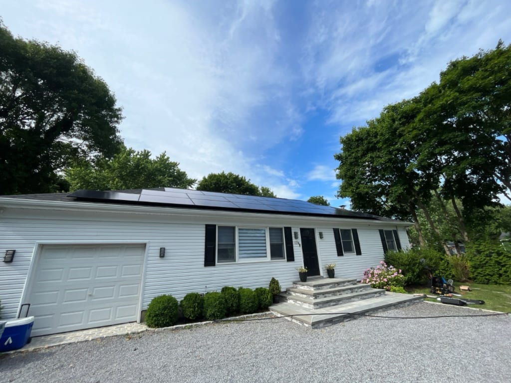Solar panels flush-mounted on a shingled Hamptons roofline at golden hour
